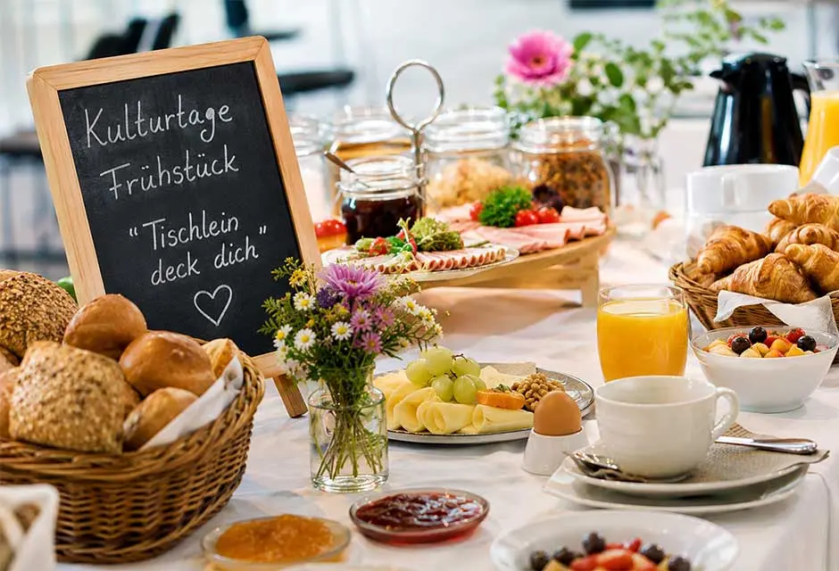 Ein gedeckter Tisch mit diversen Lebensmitteln und einer Kreidetafel