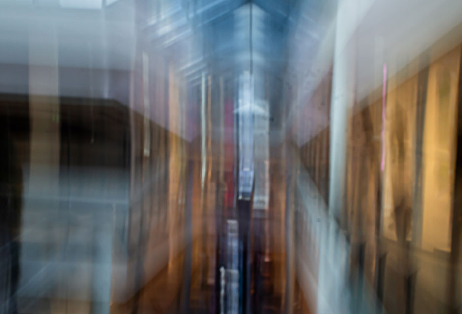 Unscharfe, verwischte Darstellung eines Flurs mit Lichtquellen und Fenstern an den Seiten
