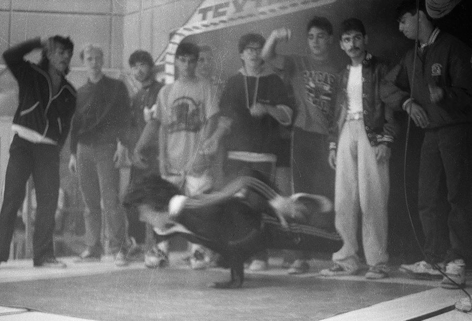 Schwarz-weiße Foto einer Gruppe Jugendlicher, die einen Breakdancer in der Mitte umringen
